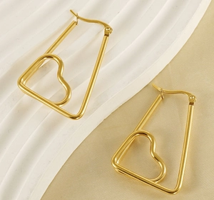 Detailed close-up of golden geometric heart earrings on elegant textured background