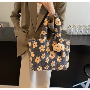 Detail of plush floral tote bag texture with cute sheep keychain and soft faux fur material