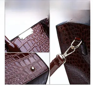 Detail view of crocodile pattern wine red handbag with gold hardware and studs