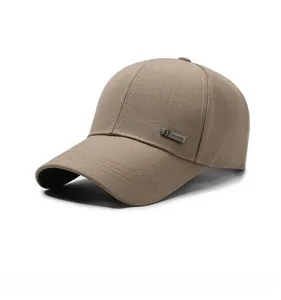 Close-up of khaki baseball cap with woven texture and silver S FASHION metal plaque