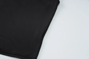 Close-up of black knitted fabric showing premium texture and precision stitching
