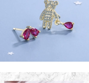 Detailed view of asymmetric bear earrings with pink gemstones and sparkling zircon studs