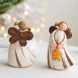 Hand-painted resin angel figurines with stars and wings in a warm festive setting