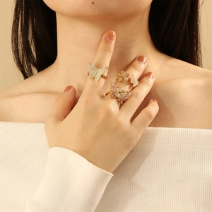 Close-up of elegant gold butterfly and flower rings set with micro-pave zircons on fingers