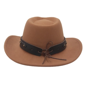 Detail of brown felt cowboy hat featuring bronze rivets and dark leather decorative band