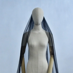 Detail view of a long single-layer black tulle bridal veil on a faceless mannequin