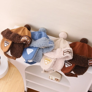 Detail view of winter bear earflap hats in four colors with Lucky embroidery and plush lining