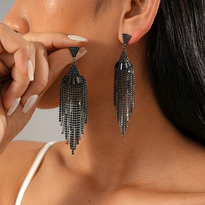 Detail of long black zircon fringe earrings with fan-shaped tassel on a model