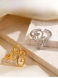 Detailed shot of gold and silver open rings with hollow geometric patterns on silk