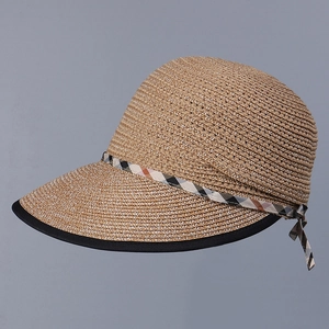 Macro detail of natural straw sun hat featuring a classic plaid ribbon bow and black edging