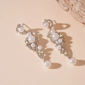 Elegant silver tassel earrings with pearls and shimmering rhinestones on a warm background