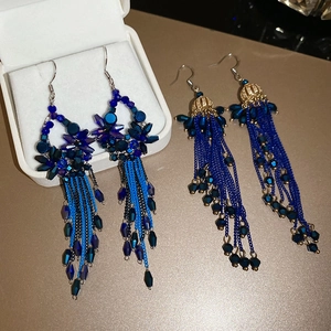 Detail of blue crystal bead fringe earrings with gold caps in a white jewelry gift box