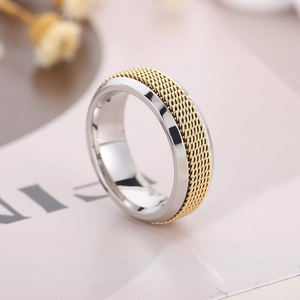 Détail d'une bague rotative bicolore avec maille tissée dorée et finition en acier argenté