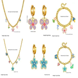 Ensemble bijoux en acier doré avec chaîne épaisse et pendentifs fleurs et papillons émaillés