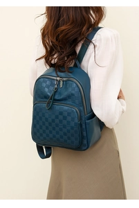 Close-up of dark blue checkerboard embossed backpack featuring a front zipper pocket