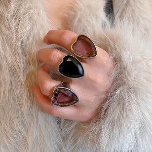 Close-up of heart-shaped zircon rings in gold and silver finish with colorful gemstones