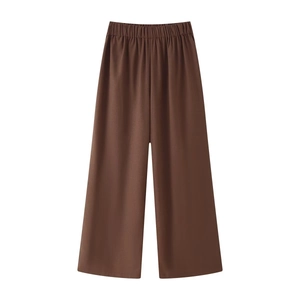 Detailed close-up of high-waist elastic waistband on dark brown wide-leg linen trousers