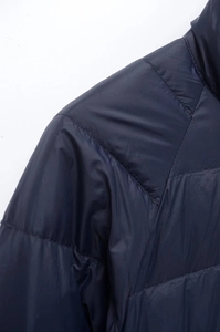 Detailed view of stitching and navy blue quilted fabric on a lightweight jacket shoulder