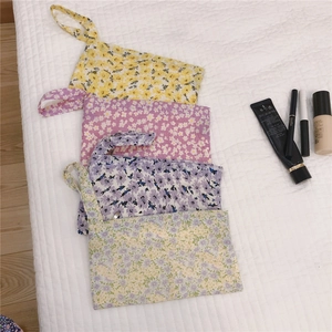 Vue détaillée de quatre pochettes en coton à fleurs avec fermeture éclair en couleurs