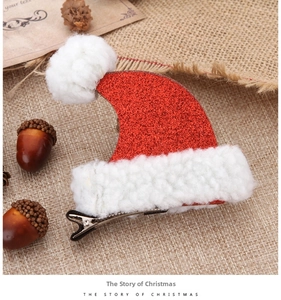 Detail of red sequined Christmas hat hair clip with white pom-pom on rustic burlap