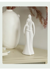 Detailed view of matte white ceramic couple sculpture in a minimalist home decor setting