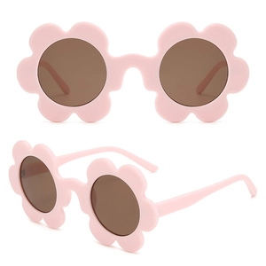 Macro view of matte light pink flower-shaped frame and dark tinted lenses on sunglasses