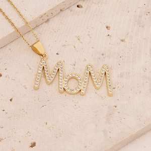 Detailed view of 18K gold plated Mom necklace with micro-pave zircons on stone background