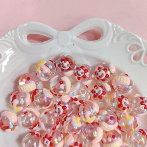 Detailed macro view of iridescent acrylic beads with flower smiley faces in a ceramic tray
