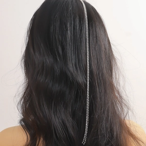 Elegant silver rhinestone chain hair clip accessory on long wavy hair for women