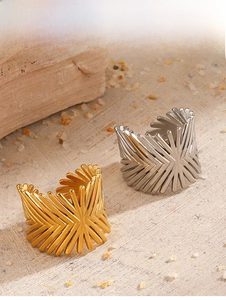 Detailed view of geometric sunburst open rings in gold and silver finish on stones