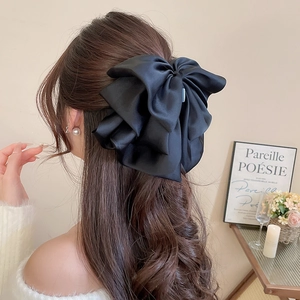 Detail of elegant black satin oversized multi-layered bow hair claw clip for women