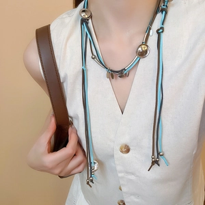 Detail of bohemian faux suede layered necklace with silver polished metal charms and beads