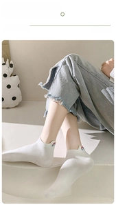 Close-up of white ankle socks featuring rainbow embroidery and reinforced heel design