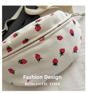 Detail of cream corduroy waist bag featuring red strawberry embroidery and rope zipper