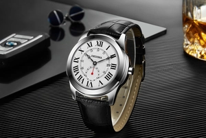 Elegant Dedima men's watch with Roman numerals and black leather strap on a luxury desk setting