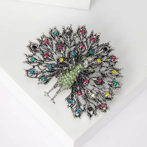 Detailed view of peacock brooch featuring vintage silver metal and vibrant green rhinestones