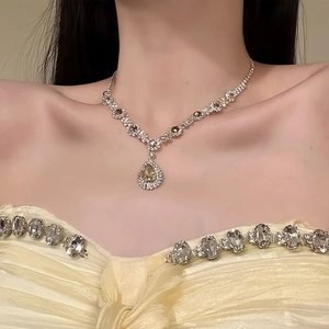 Detail of luxury necklace with champagne pear-cut diamond and pavé crystals on neck