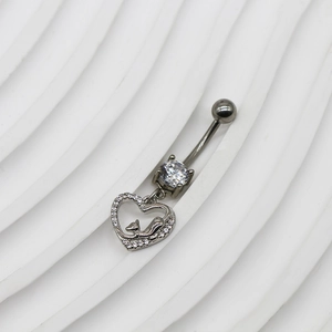 Macro d'un piercing au nombril en acier avec pendentif coeur évidé et chat