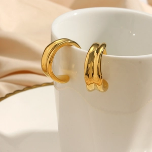 Chic 18K gold plated C-shape irregular hoop earrings displayed on white ceramic cup