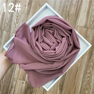 Détail macro d'une écharpe en mousseline rose poudré avec paillettes dorées en rose