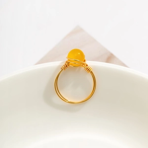 Detail of bohemian gold wire wrapped ring featuring a yellow cat eye stone bead