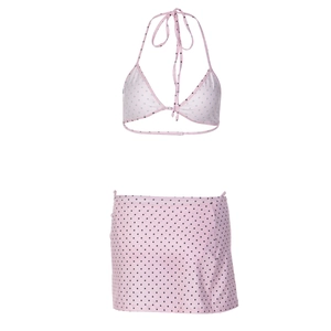 Detailed view of pink polka dot bikini top and matching swim skirt set on white background