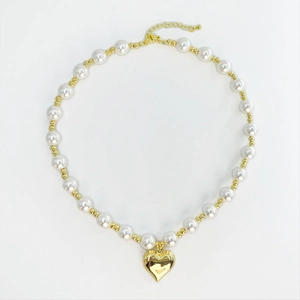 Elegant white pearl necklace with large polished gold heart pendant and adjustable clasp