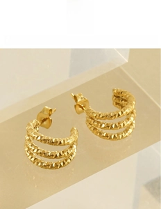 Close-up of gold-plated triple C-shape earrings featuring detailed woven texture on titanium steel