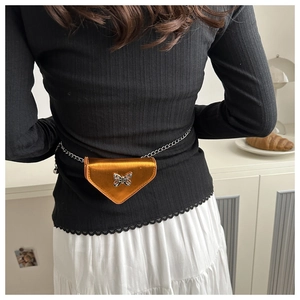 Détail du sac banane triangle bronze métallisé avec papillon argenté et chaîne