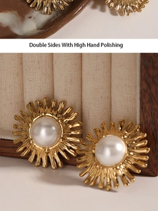 Close-up of golden sunflower pearl earrings with high hand polishing on wooden stand