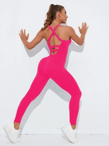 Detailed back view of a magenta yoga jumpsuit with criss-cross straps and open back