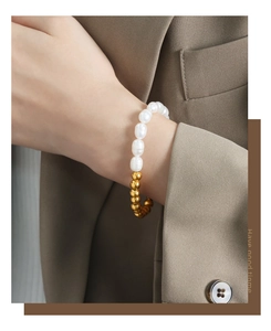 Close-up of freshwater pearl and gold bead mixed bracelet on a model's wrist
