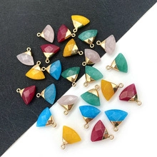 Macro detail of faceted natural stone shield pendants with gold plated edges on dual background