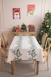 Macro detail of Christmas tablecloth with holly leaf and red berry print on beige fabric